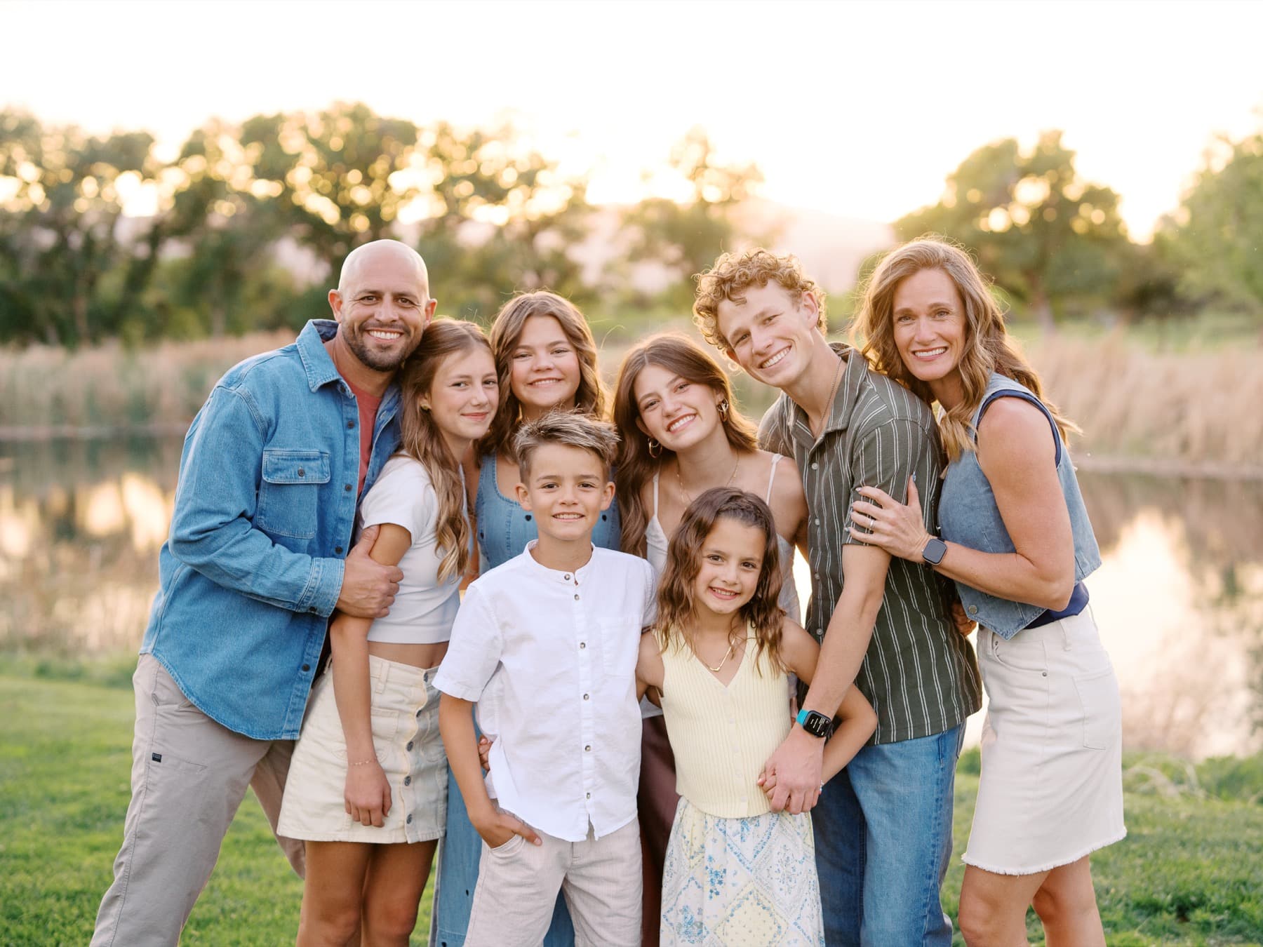 Natalie and family beside water at sunset
